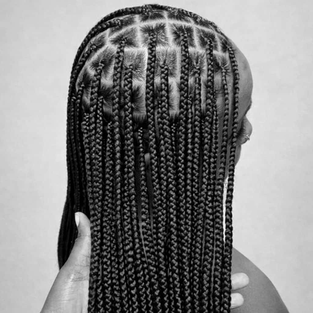 Knotless braids en cours de pose par une coiffeuse