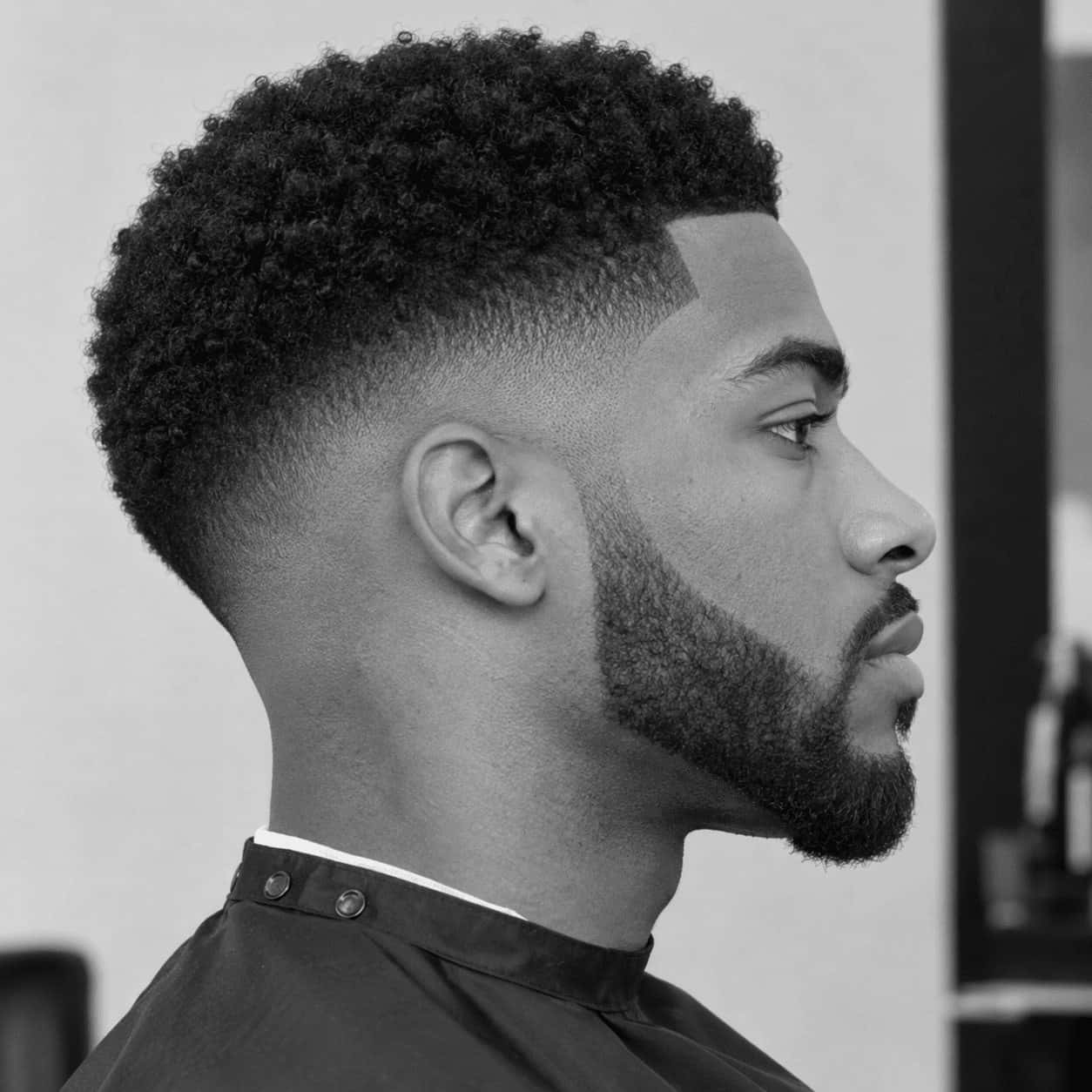 Homme de profil avec un dégradé afro et une barbe taillée