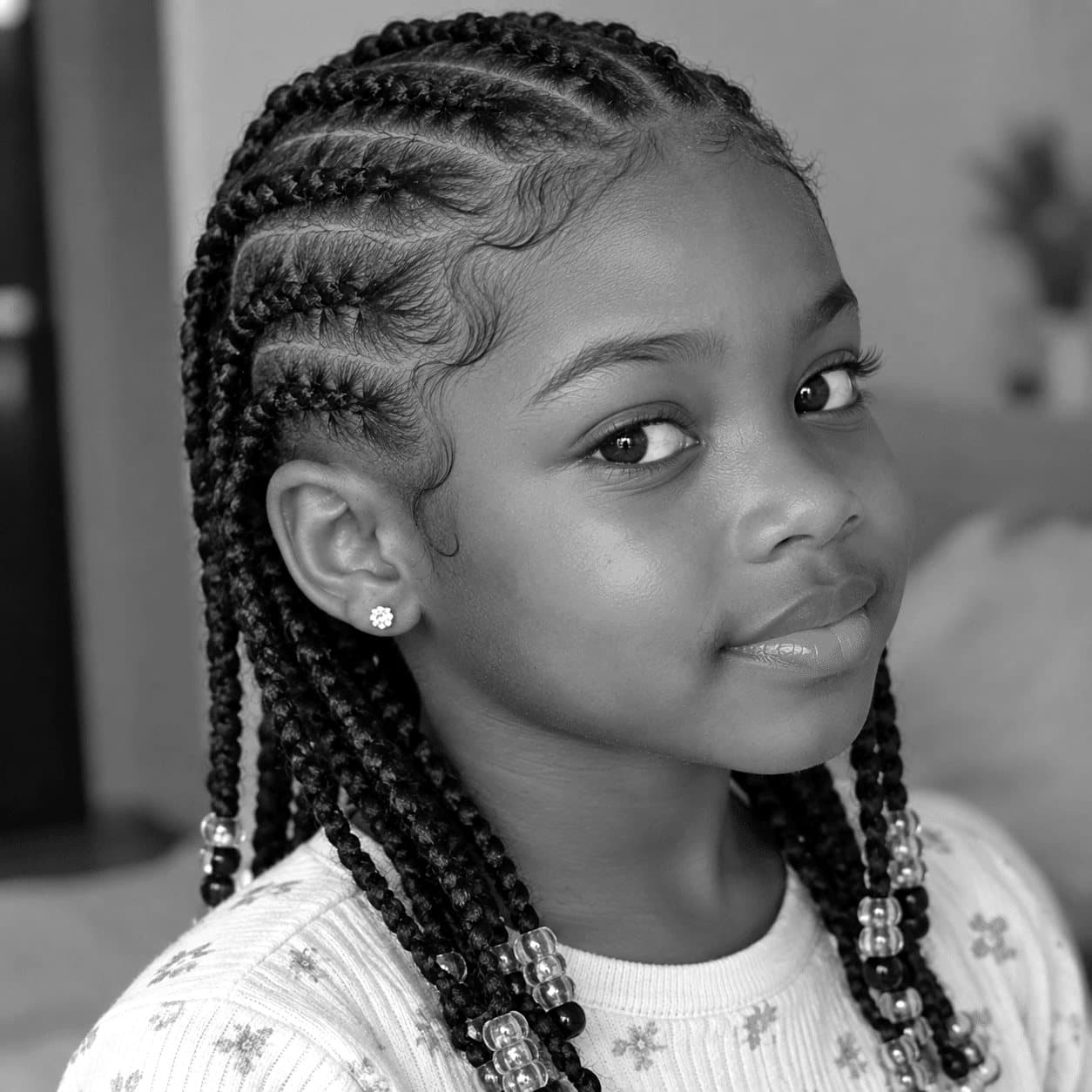 Petite fille avec des tresses et des perles